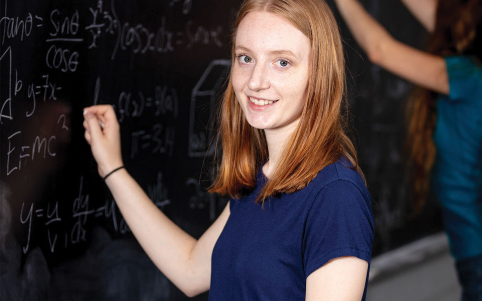 Mathematics and statistics student working on a blackboard